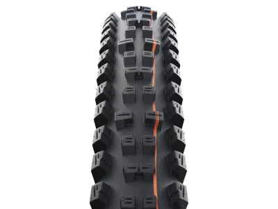Close-up of a tire with prominent tread pattern on a white background